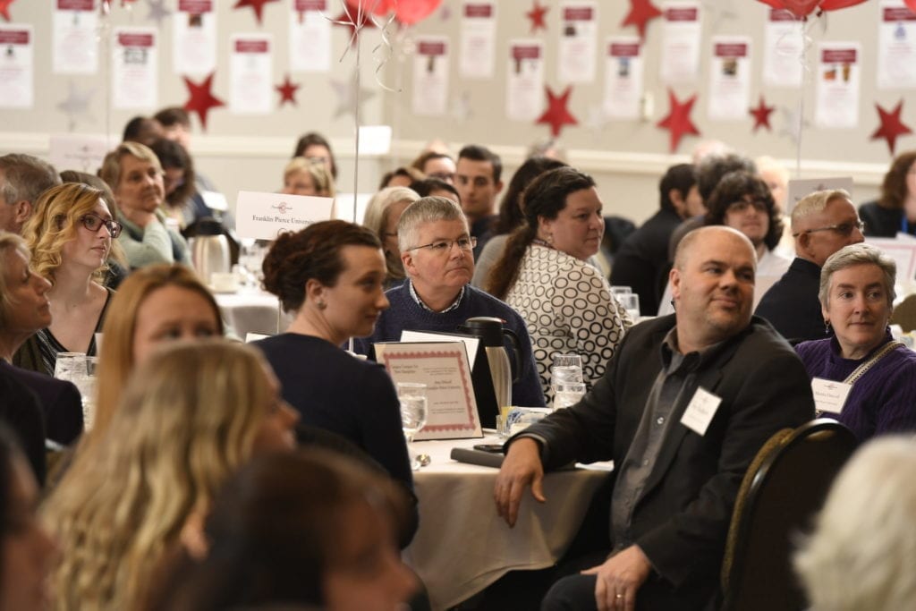 Tables of people watching presentation