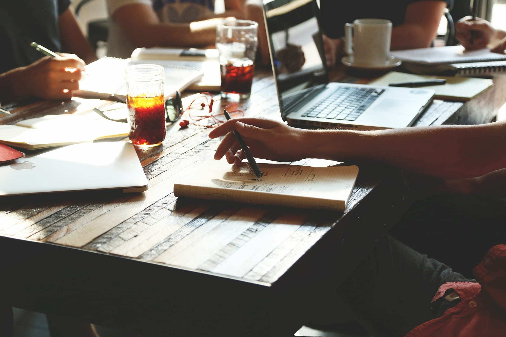 Table with coffee and computers on it